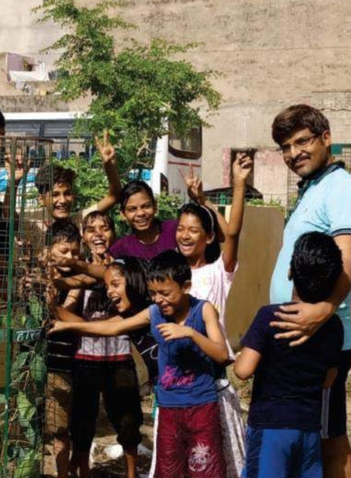 Founder of Oshi Foundation interacting with slum children, promoting education, hygiene, and community support